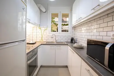 a white kitchen with a sink and a microwave at Apollon Apartment and Museum Acropolis in Athens