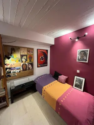 a bedroom with a bed and a purple wall at Cozy quiet studio near the sea in Athens