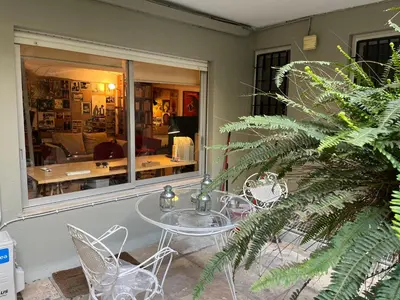 a glass table and chairs in front of a window at Cozy quiet studio near the sea in Athens