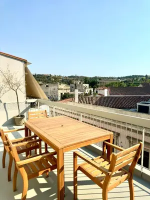 a wooden table and chairs on top of a roof at GRACE Apartment Next to the Akropolis in Athens