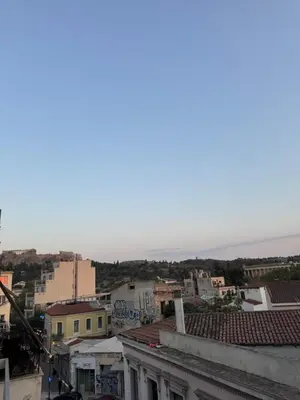 a view of a city with the ocean in the background at GRACE Apartment Next to the Akropolis in Athens