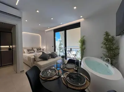 a living room with a table and a bath tub at BlueMotion - PortSuite 5A in Piraeus