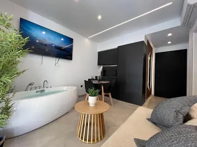 a bathroom with a tub and a tv on the wall at BlueMotion - PortSuite 5A in Piraeus