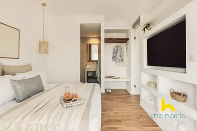 a bedroom with a large bed with a flat screen tv at Marina View Haven - King Beds and Cosy Fireplace in Piraeus