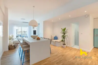 a kitchen and living room with a table and chairs at Marina View Haven - King Beds and Cosy Fireplace in Piraeus