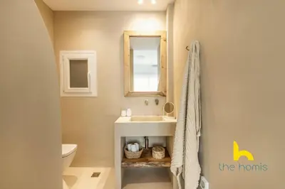 a bathroom with a sink and a toilet and a mirror at Marina View Haven - King Beds and Cosy Fireplace in Piraeus