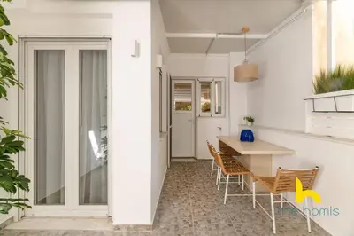 a kitchen and dining room with a table and chairs at Marina View Haven - King Beds and Cosy Fireplace in Piraeus