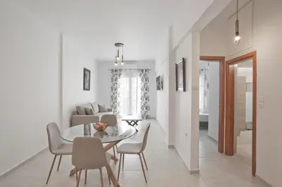 a dining room and living room with a table and chairs at SeaLiv Apartment by LobbySquare in Piraeus