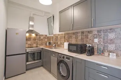 a kitchen with a refrigerator and a washer and dryer at SeaLiv Apartment by LobbySquare in Piraeus