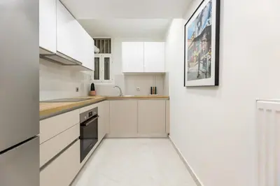 a white kitchen with white cabinets and a sink at Bright and Stylish Apartment in Palaio faliro in Athens