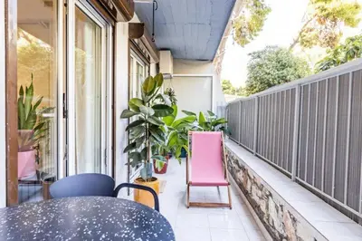 a balcony with a table and chairs and plants at Bright and Stylish Apartment in Palaio faliro in Athens