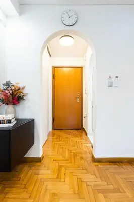 a hallway with a door and a clock on the wall at Bright and Stylish Apartment in Palaio faliro in Athens