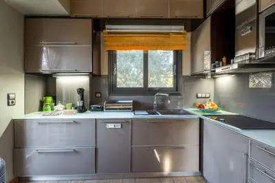 a kitchen with stainless steel appliances and a window at Indoor pool villa, near the beach, Lagonisi in Kalívia Thorikoú
