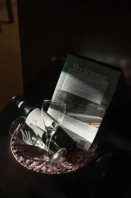 a basket with a wine glass and a magazine at Indoor pool villa, near the beach, Lagonisi in Kalívia Thorikoú