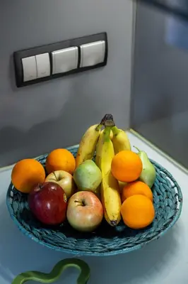 a bowl of fruit on a counter with apples and oranges at Indoor pool villa, near the beach, Lagonisi in Kalívia Thorikoú