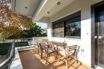 a patio with a wooden table and chairs at Indoor pool villa, near the beach, Lagonisi in Kalívia Thorikoú