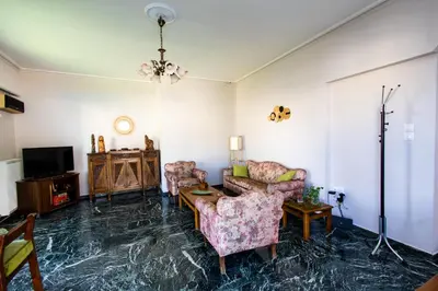 a living room with two chairs and a tv at Ρετιρέ με θέα in Athens