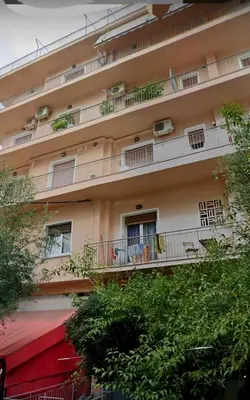 a large apartment building with balconies and tables and chairs at Ρετιρέ με θέα in Athens