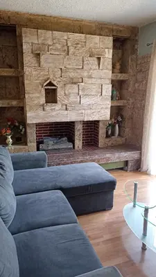 a living room with a blue couch and a fireplace at Penth3 in Athens