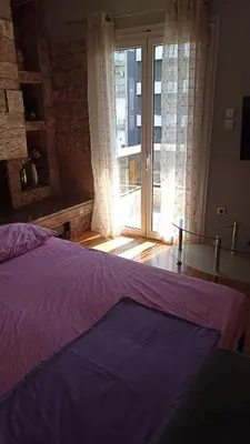 a bedroom with a purple bed and a large window at Penth3 in Athens