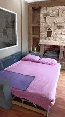 a large bed in a room with a brick wall at Penth3 in Athens