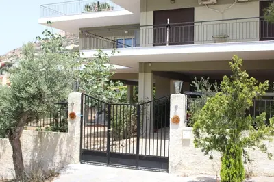 a house with a black gate in front of it at Thenia's Bellevue apartment in Saronida