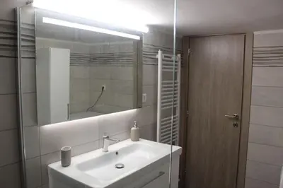 a bathroom with a white sink and a mirror at Thenia's Bellevue apartment in Saronida