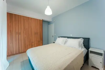 a bedroom with a bed and a wooden cabinet at Aegean escape house in Artemida