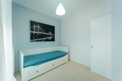 a bedroom with a bed with blue sheets and a picture on the wall at Aegean escape house in Artemida