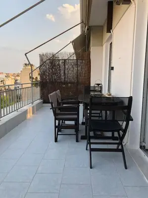 a balcony with chairs and a table on a building at Are You Renti in Piraeus