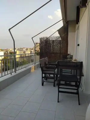 a balcony with chairs and a table on a building at Are You Renti in Piraeus