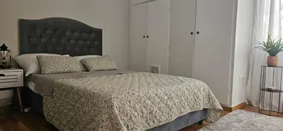 a bedroom with a large bed with a large headboard at Cozy and quiet apartment , convenient location in Athens in Athens