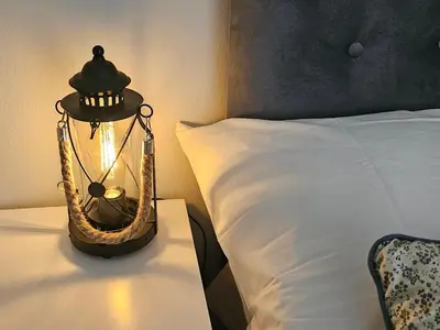 a lantern sitting on a table next to a bed at Cozy and quiet apartment , convenient location in Athens in Athens