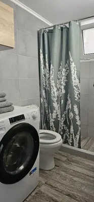 a bathroom with a washing machine and a toilet at Cozy and quiet apartment , convenient location in Athens in Athens