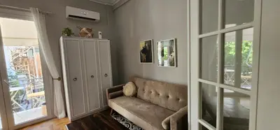 a living room with a couch next to a door at Cozy and quiet apartment , convenient location in Athens in Athens