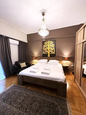 a bedroom with a large bed and a chandelier at Art Interior Apartment in Athens next to Metro Stations & All Hospitals in Athens