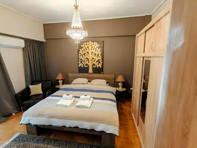 a bedroom with a large bed and a chandelier at Art Interior Apartment in Athens next to Metro Stations & All Hospitals in Athens