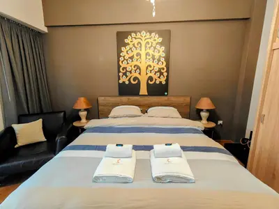 a bedroom with two beds and a couch at Art Interior Apartment in Athens next to Metro Stations & All Hospitals in Athens
