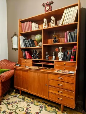 a wooden book shelf with books on it at Art Interior Apartment in Athens next to Metro Stations & All Hospitals in Athens