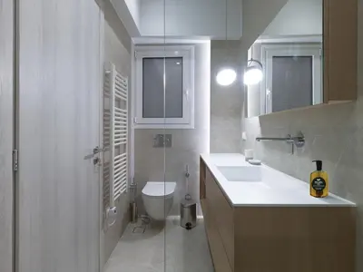 a white bathroom with a toilet and a sink at Chic and modern apartment in the center of Kolonaki in Athens