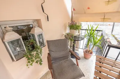 a room with a chair and a window with plants at Home 7 Minutes Away From Stavros Niarhos in Athens