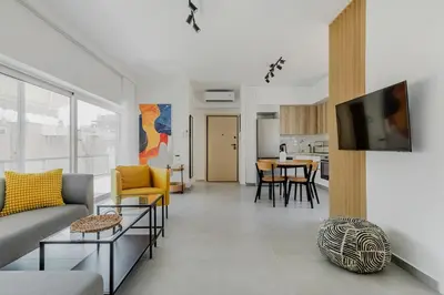 a living room with a couch and a tv on a wall at A Place 4U 20, 2 Bedrooms & 2 Bathrooms with view of Acropolis in Athens