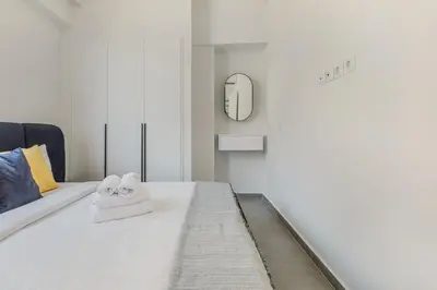 a bedroom with a white bed with a mirror at A Place 4U 20, 2 Bedrooms & 2 Bathrooms with view of Acropolis in Athens