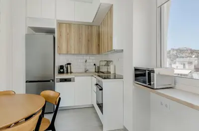 a kitchen with white appliances and a table and a window at A Place 4U 20, 2 Bedrooms & 2 Bathrooms with view of Acropolis in Athens