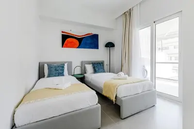 two beds in a white room with a window at A Place 4U 20, 2 Bedrooms & 2 Bathrooms with view of Acropolis in Athens