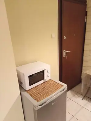 a microwave sitting on top of a refrigerator at Athens Koukaki - Metro station Sygrou-Fix closer in Athens
