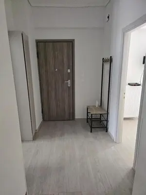 a hallway with a wooden door and a mirror at Ovelix apartment in Athens
