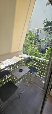 a table and chair in a room with a large window at Ovelix apartment in Athens