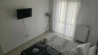 a room with a room with a television and a table at Ovelix apartment in Athens