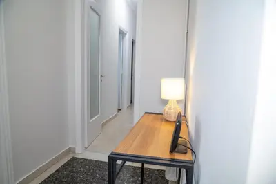 a hallway with a table with a lamp on it at Spacious 2 BR apartment next to Acropolis in Athens